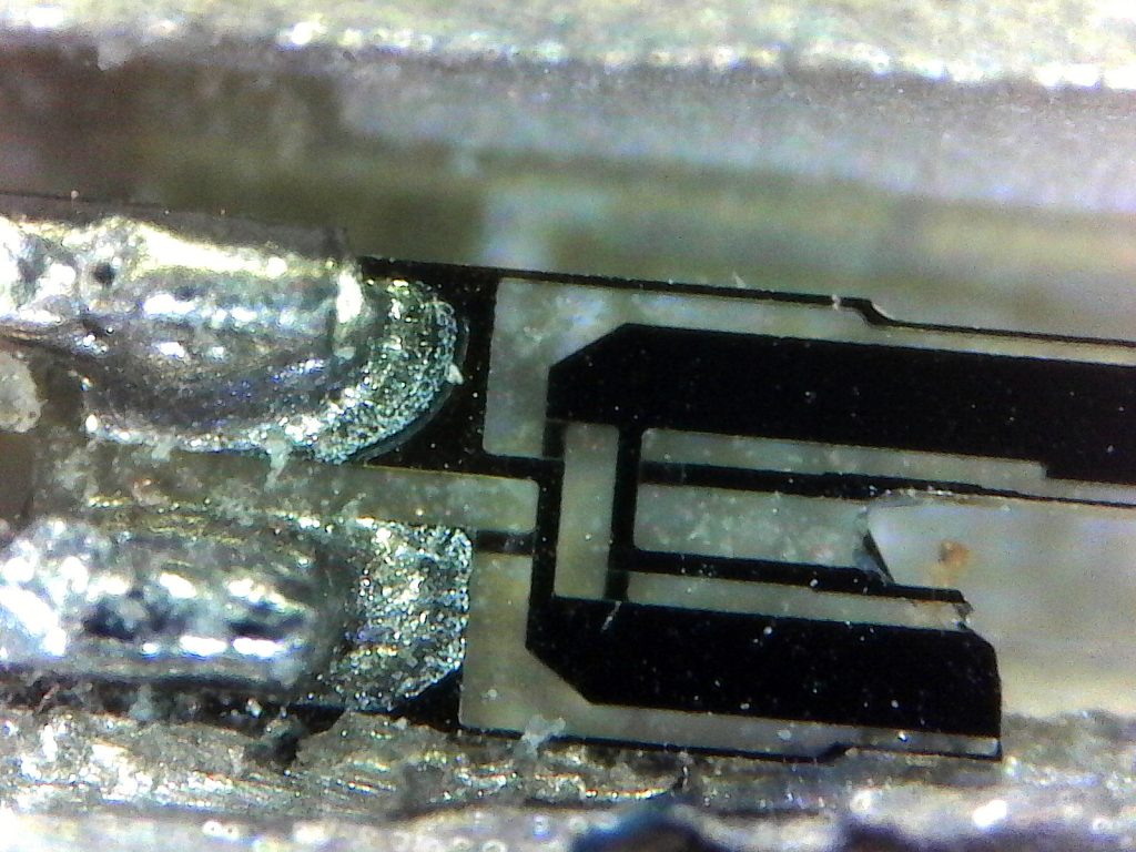 A close-up of the base of the tuning fork, showing the electrical connections and solder joints.